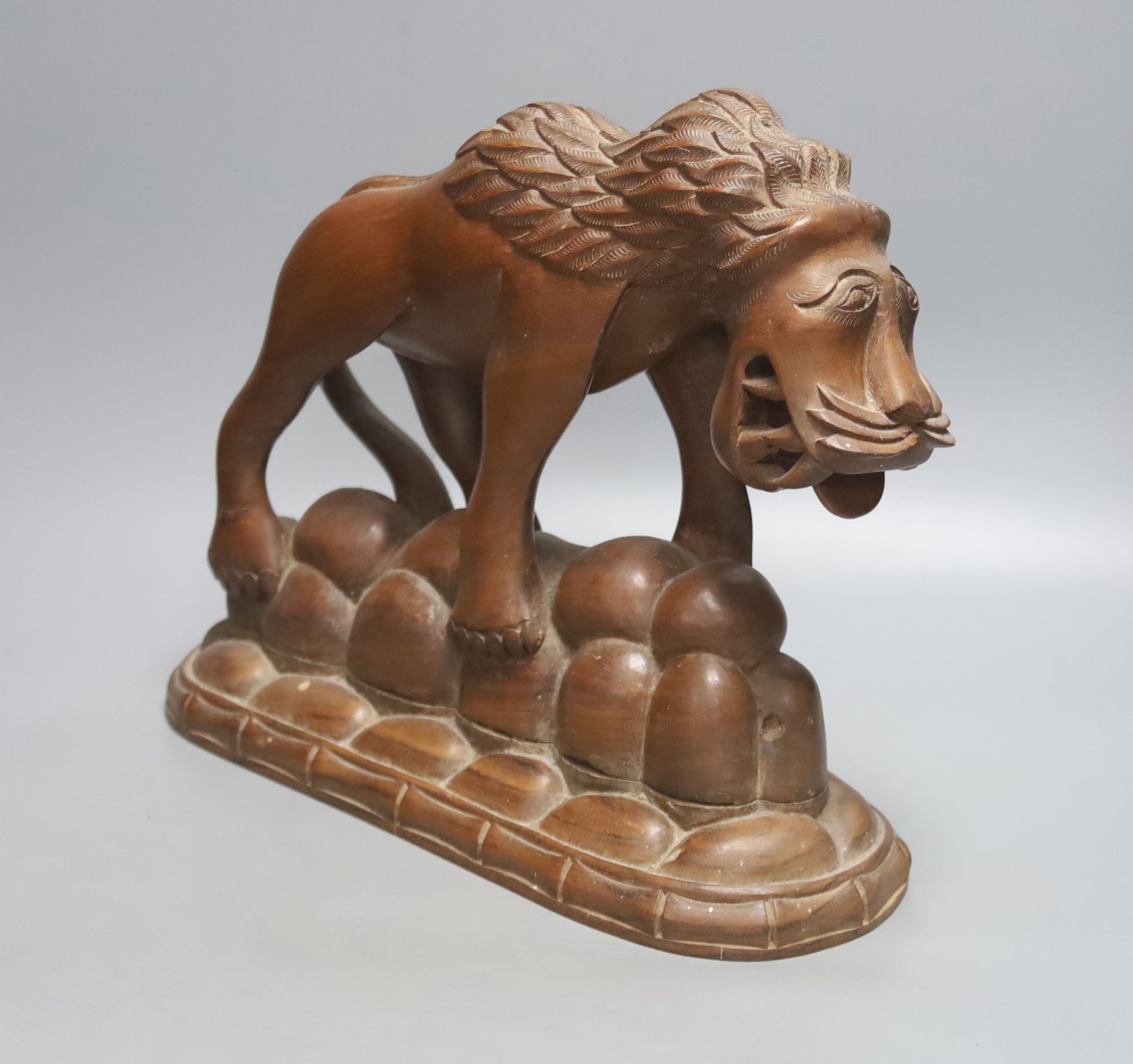 An Asian carved hardwood model of a lion, height 26cm